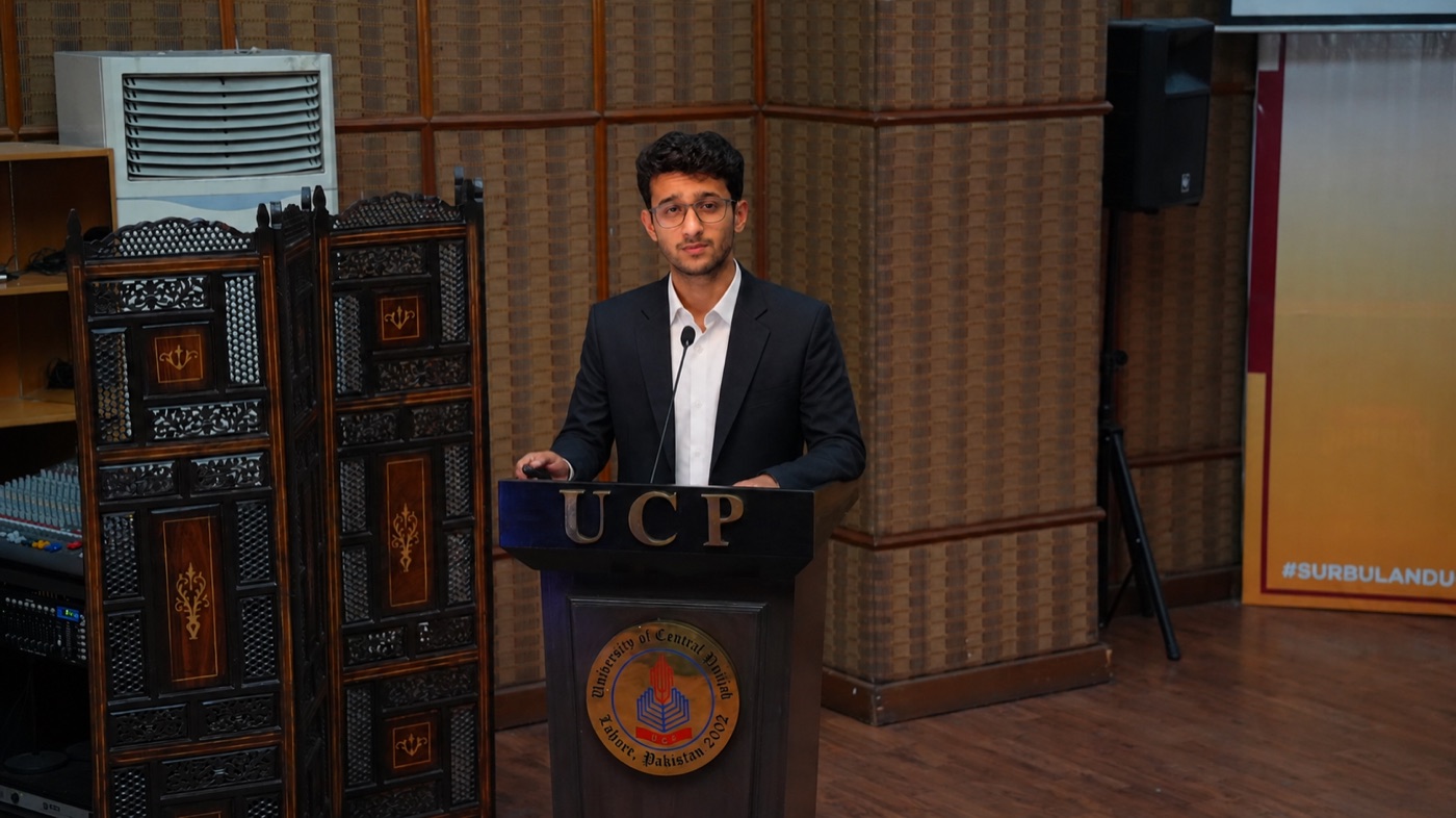 Huzaifa Iftikhar speaking at a podium